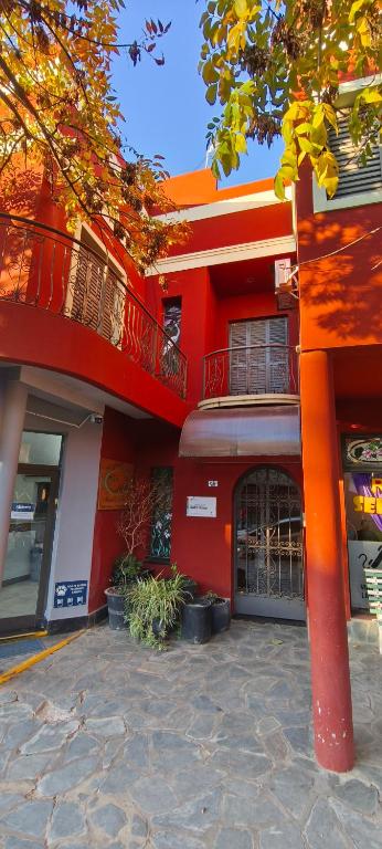 a red building with a balcony on the side of it at Alojamiento Tía Silvia in San José