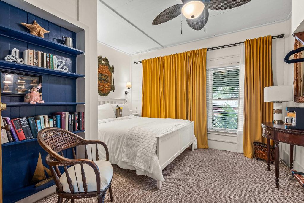 a bedroom with a bed and a book shelf at Old Carrabelle Hotel Regatta Room in Carrabelle