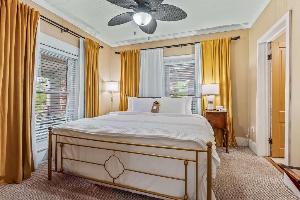 a bedroom with a bed and a ceiling fan at Old Carrabelle Hotel Hemingway Suite in Carrabelle