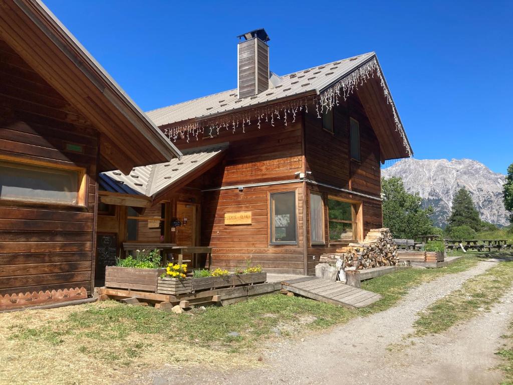 a log cabin with a porch and mountains in the background at Ferme de la Clarée in Névache