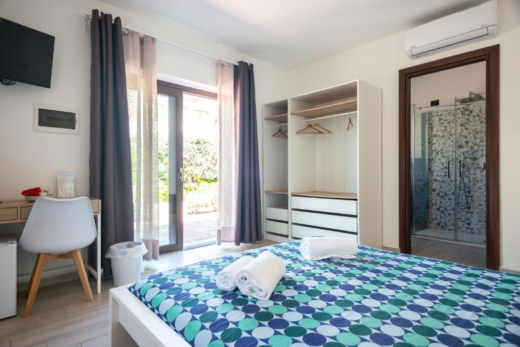 a bedroom with a bed and a large window at Zenia Rooms in San Teodoro