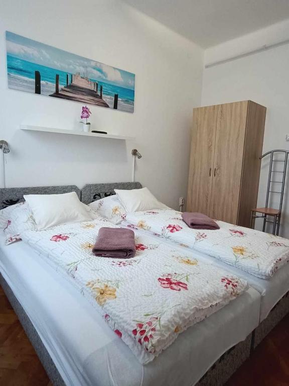 a bedroom with a large white bed with flowers on it at Pagoda Vendégház in Hajdúdorog