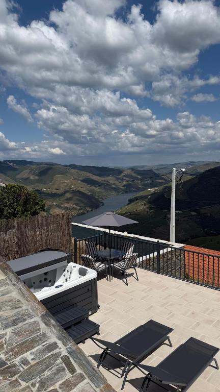a patio with a grill and a table and chairs at River Breeze Douro - Casa Touriga in Marmelal