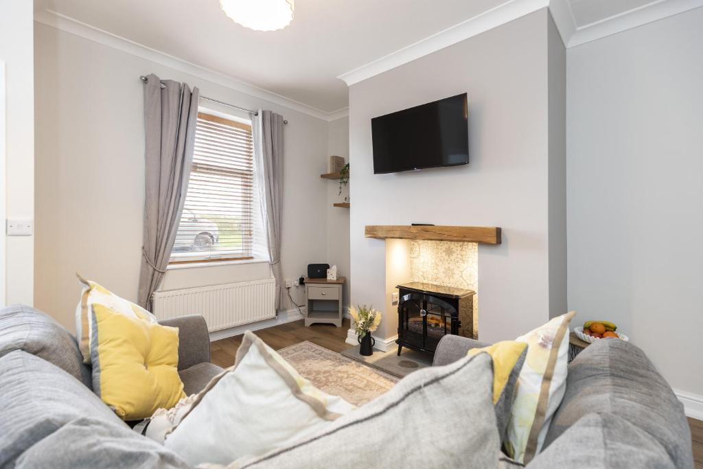 a living room with a couch and a fireplace at High Lands in Cockfield