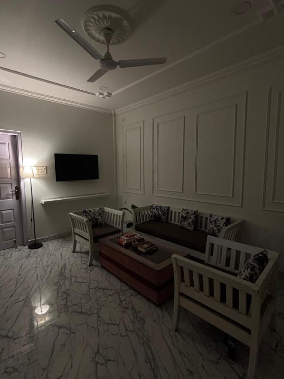 a living room with a couch and chairs and a tv at Aashiyana retreat in Duimukh