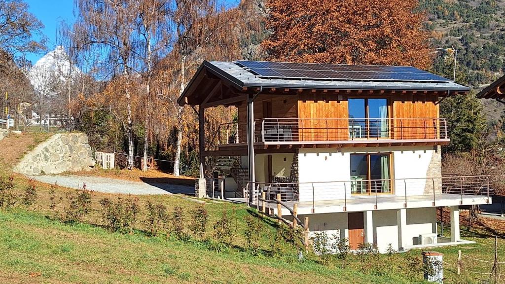 a house with solar panels on top of it at LA CASETTA - Appartamento CERVINO in Torgnon