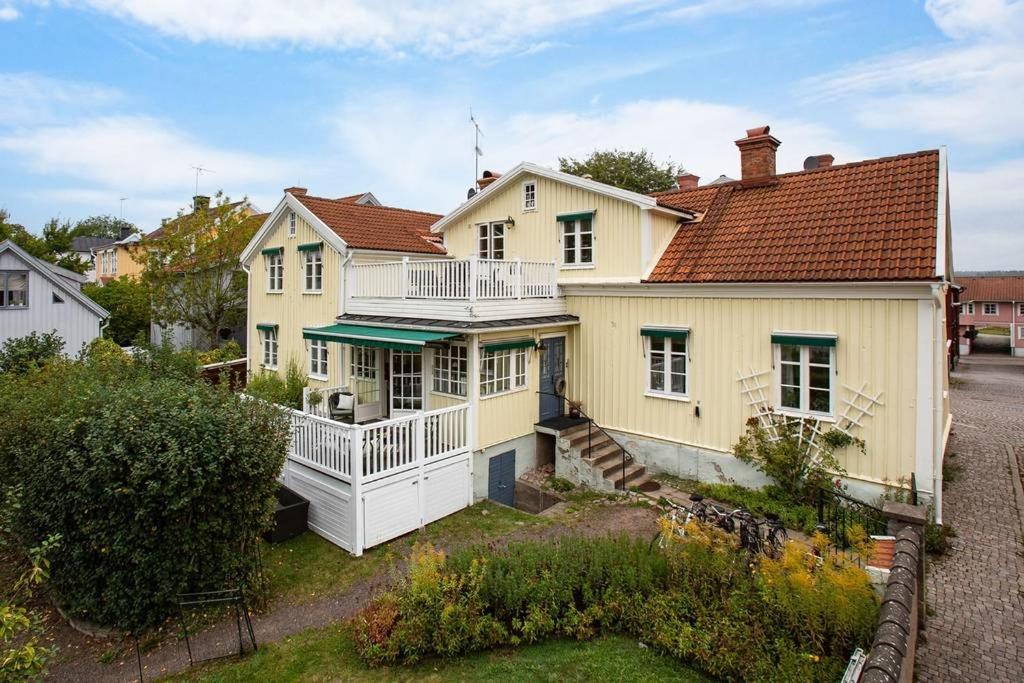 a large yellow house with a porch and a balcony at Storgatan 30 i centrala Vimmerby in Vimmerby