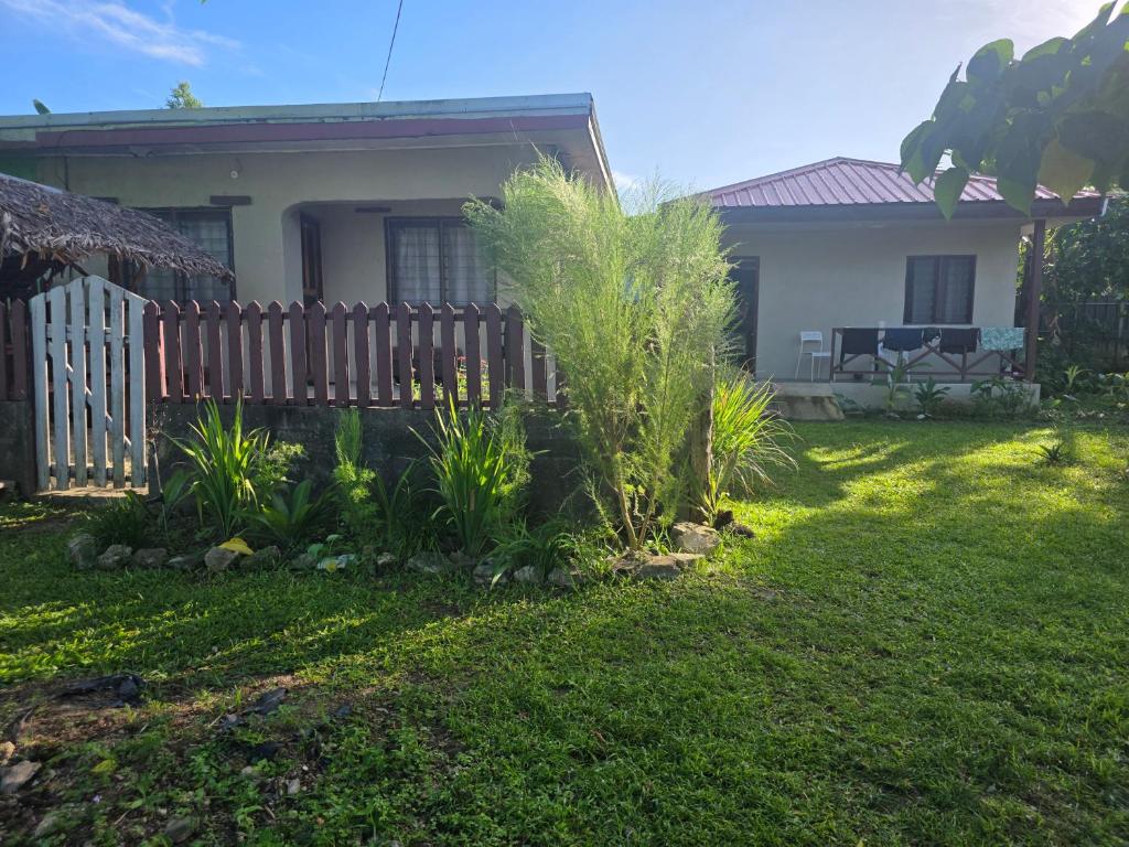 a house with a fence and plants in the yard at G&A Friendly stay in Port Vila