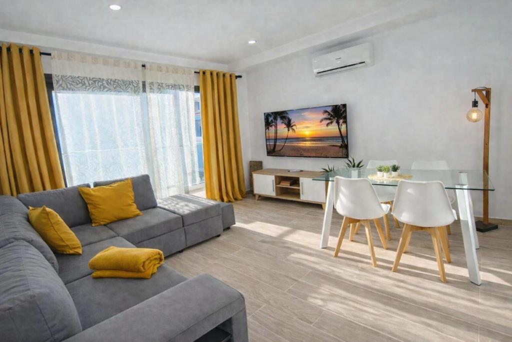 a living room with a couch and a table with chairs at Deluxe Arguineguin Beach in Arguineguín