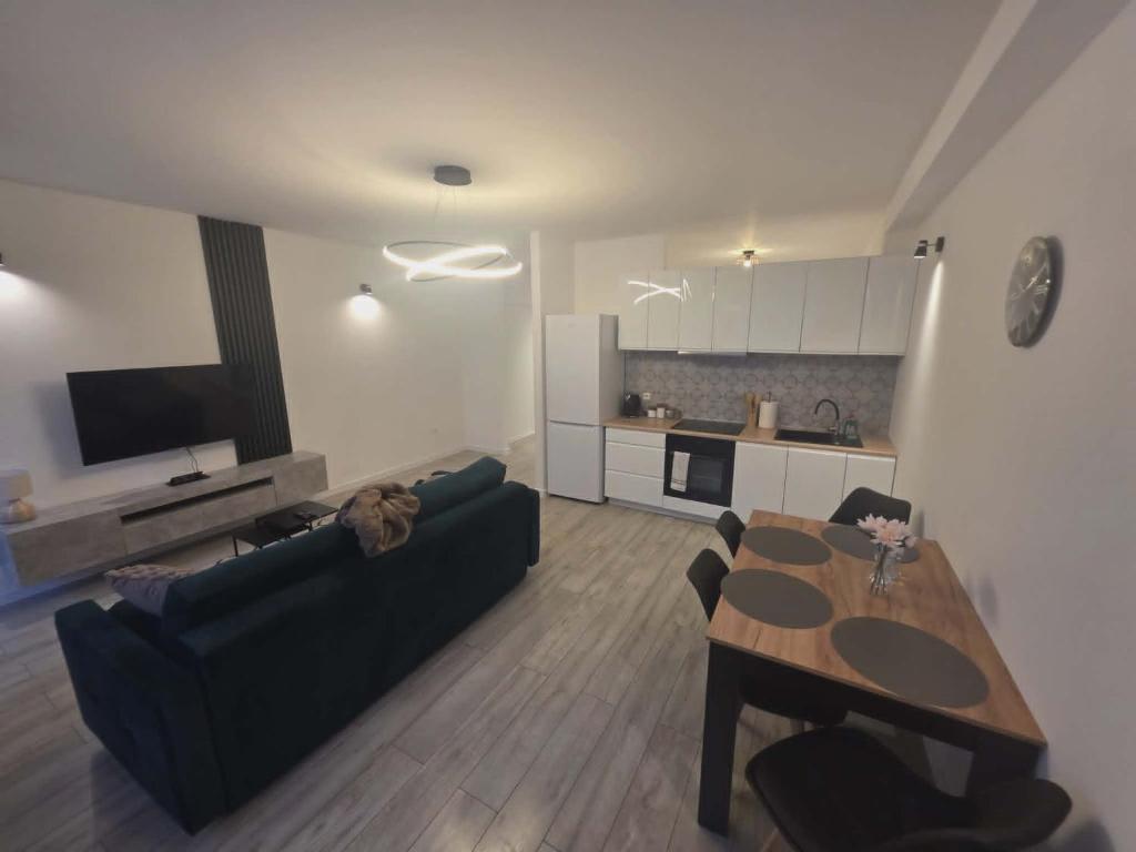 a living room with a black couch and a table at Apartament Anny 1 in Grodzisk Mazowiecki