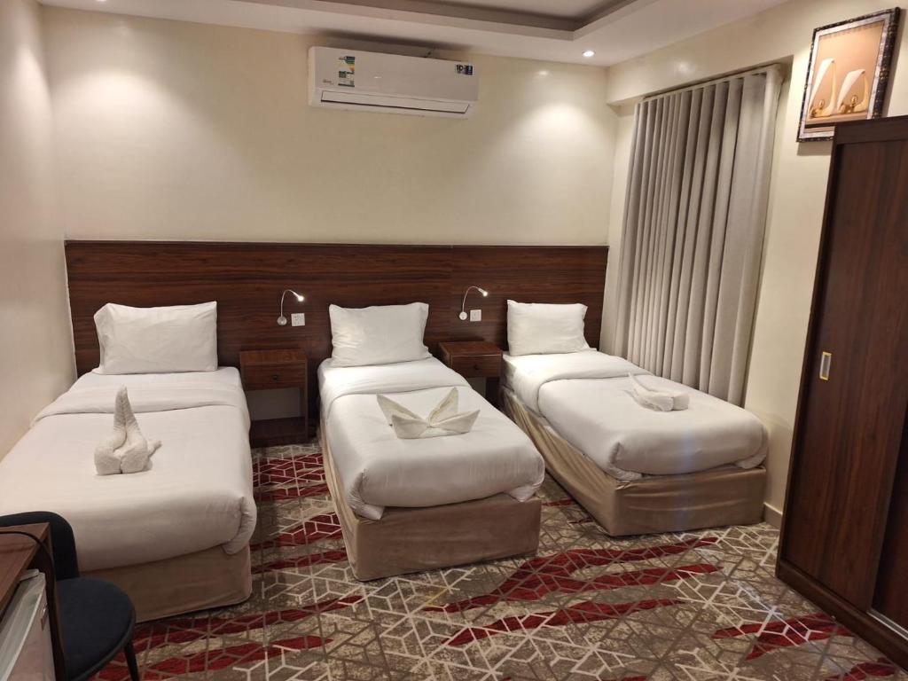 a hotel room with two twin beds and a window at Hotel Lujain Al Dhahabi Star in Al ‘Awālī