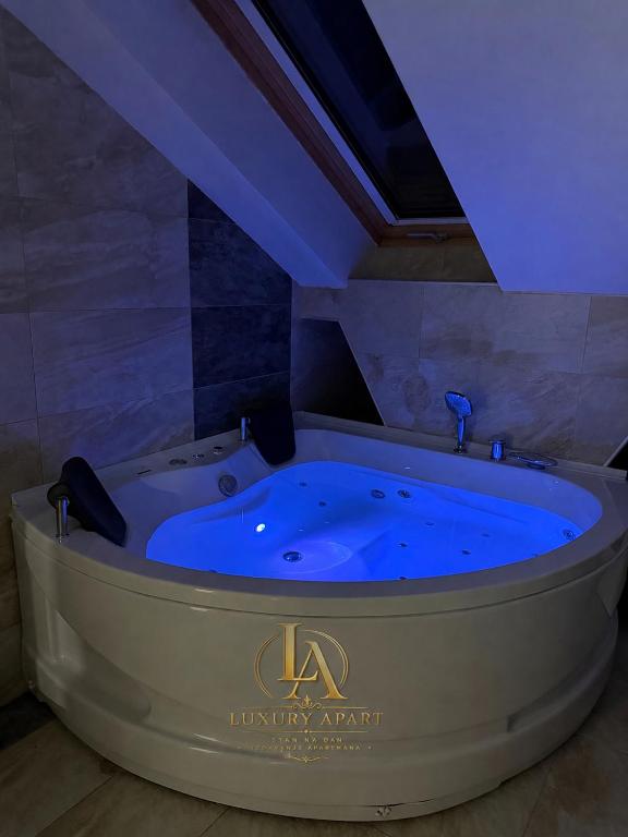 a jacuzzi tub in a room with blue lighting at Luxury Apartments in Brčko