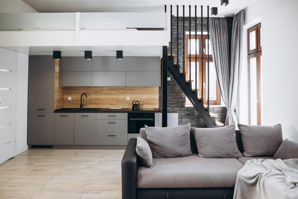 a living room with a couch and a kitchen at Apartament Centrum Żywiec - GROJEC in Żywiec