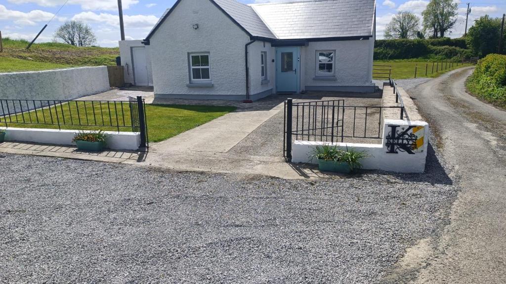 a house with a gate and plants in front of it at Kelly's Country Cottage in Rookwood