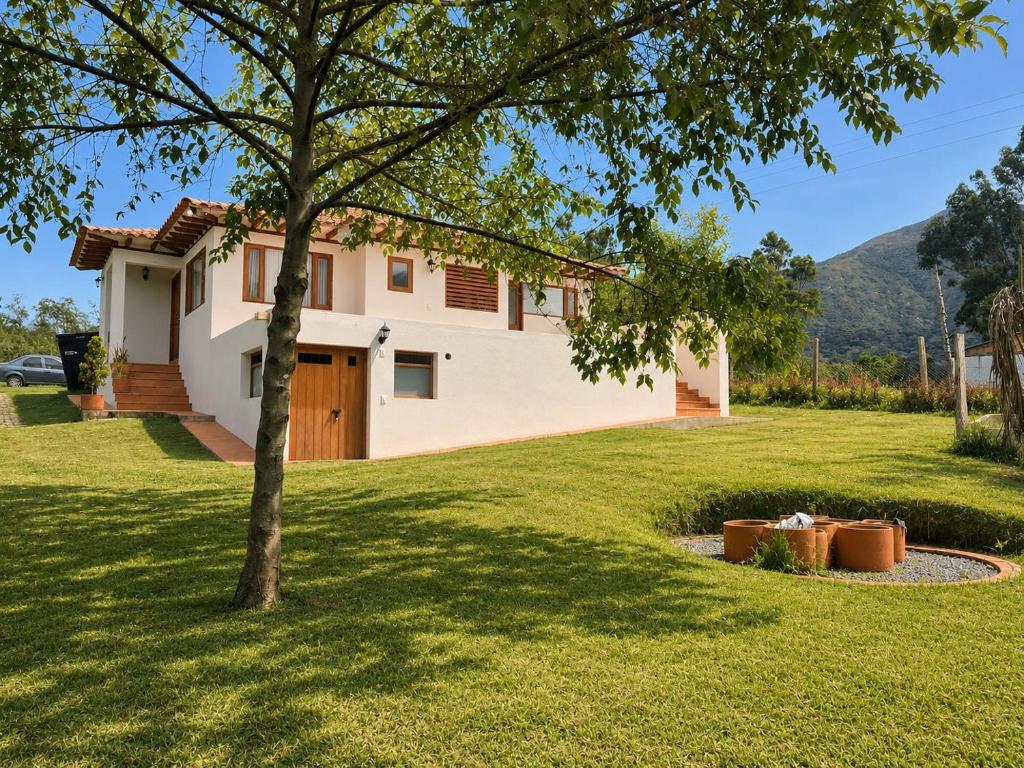 a house with a tree in the yard at Casa Silvestre in Villa de Leyva