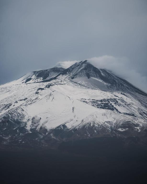 a mountain covered in snow and ice on top at Appartamentino Mansardato in Pedara