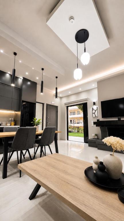 a kitchen and living room with a table and chairs at Anemos Suites Loutraki in Loutraki
