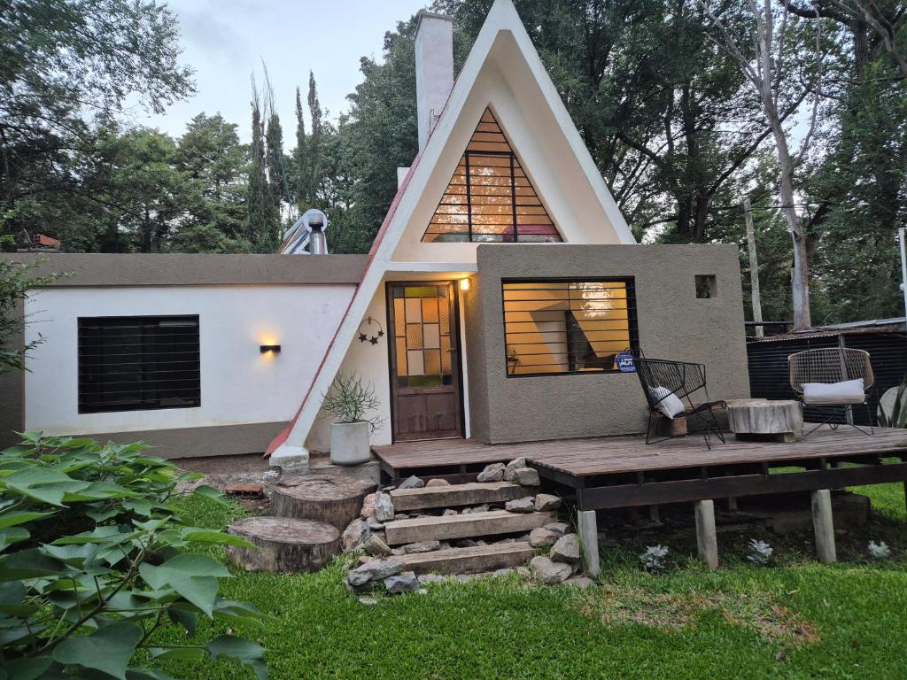 a small house with a triangular roof in a yard at Estrellita Mia in Villa Ciudad Parque