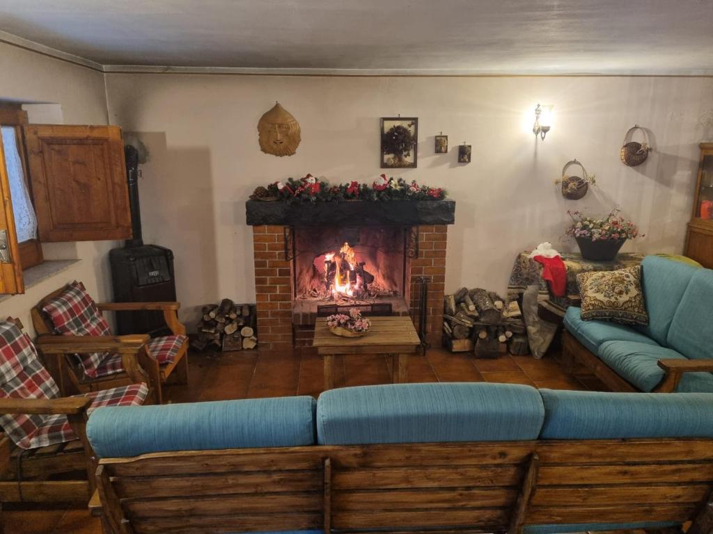a living room with a fireplace and a blue couch at Cottage Etna nel Cuore in Nicolosi