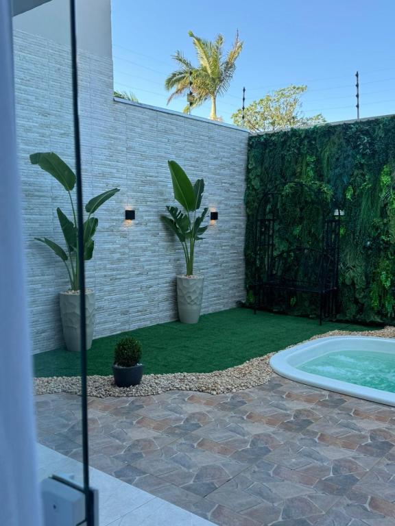a backyard with a swimming pool and plants at POUSADA DONATELLA Modernidade e conforto para noites tranquilas in Paranaguá