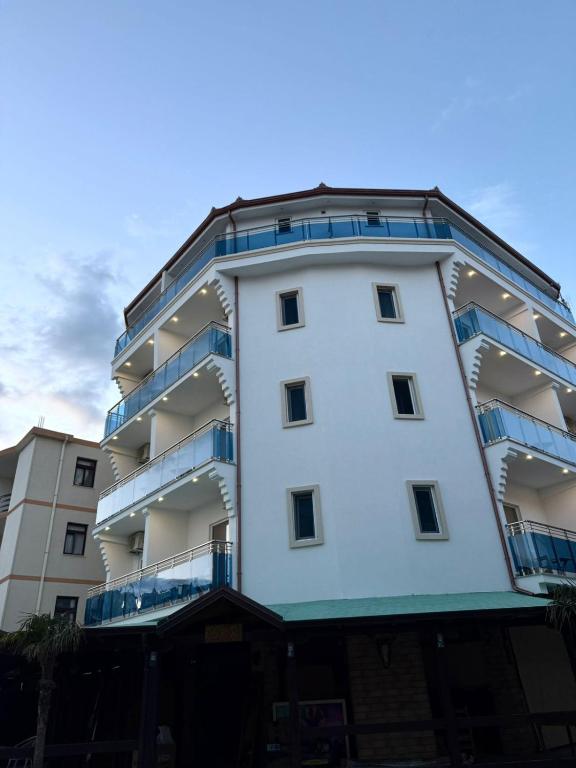 a white building with blue balconies on it at Kompleksi Jakaj in Velipojë