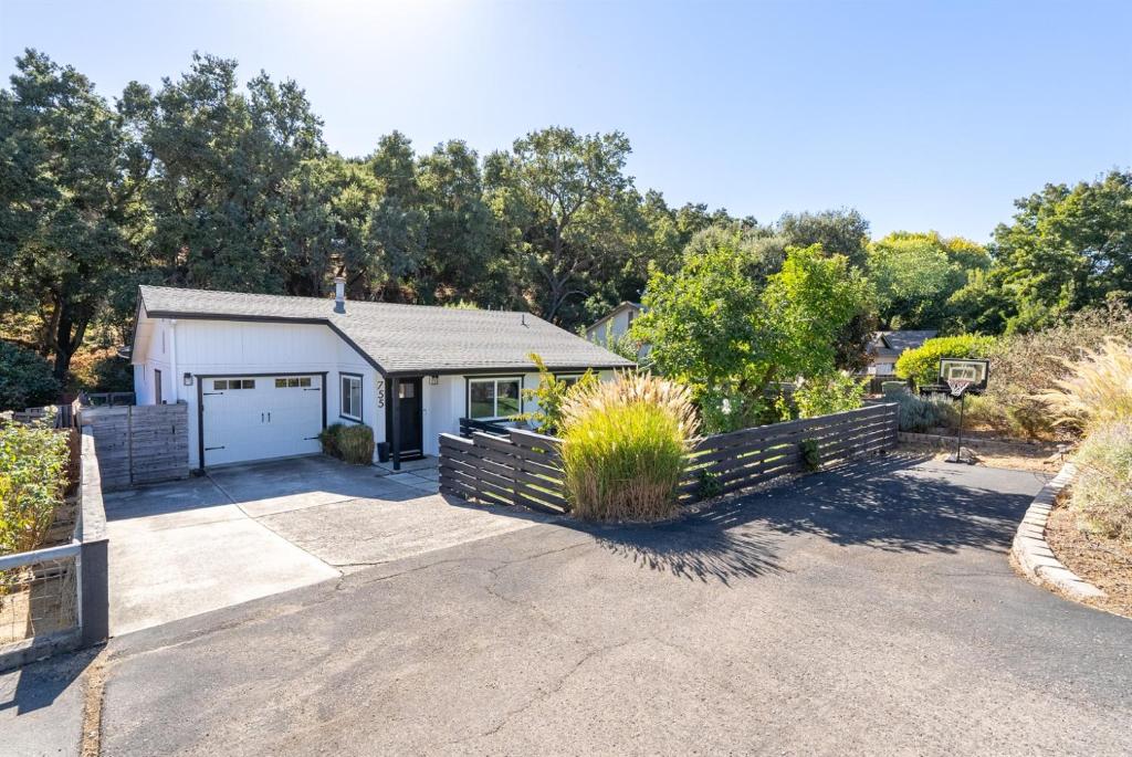 a house with a garage and a driveway at Templeton Creekside Cottage Walk to Downtown in Templeton