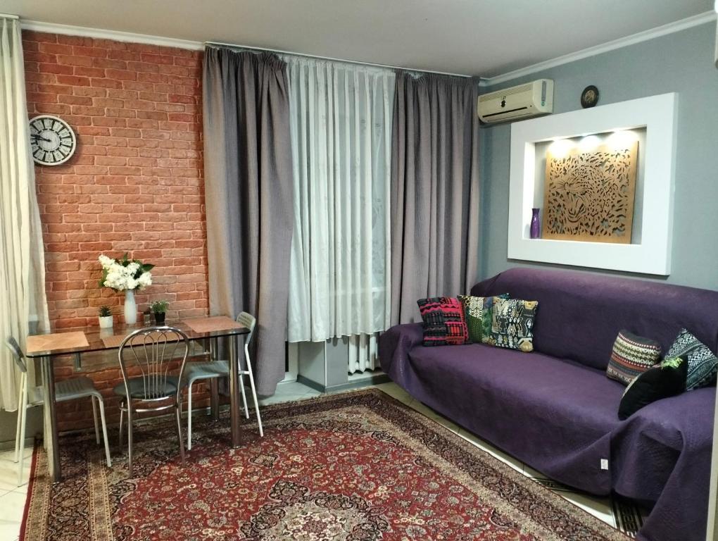 a living room with a purple couch and a table at Apartment on 8 Marta in Mykolaiv
