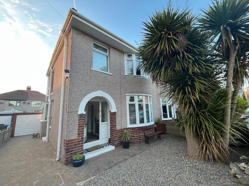 a house with a palm tree in front of it at Summer Salt house in Morecambe
