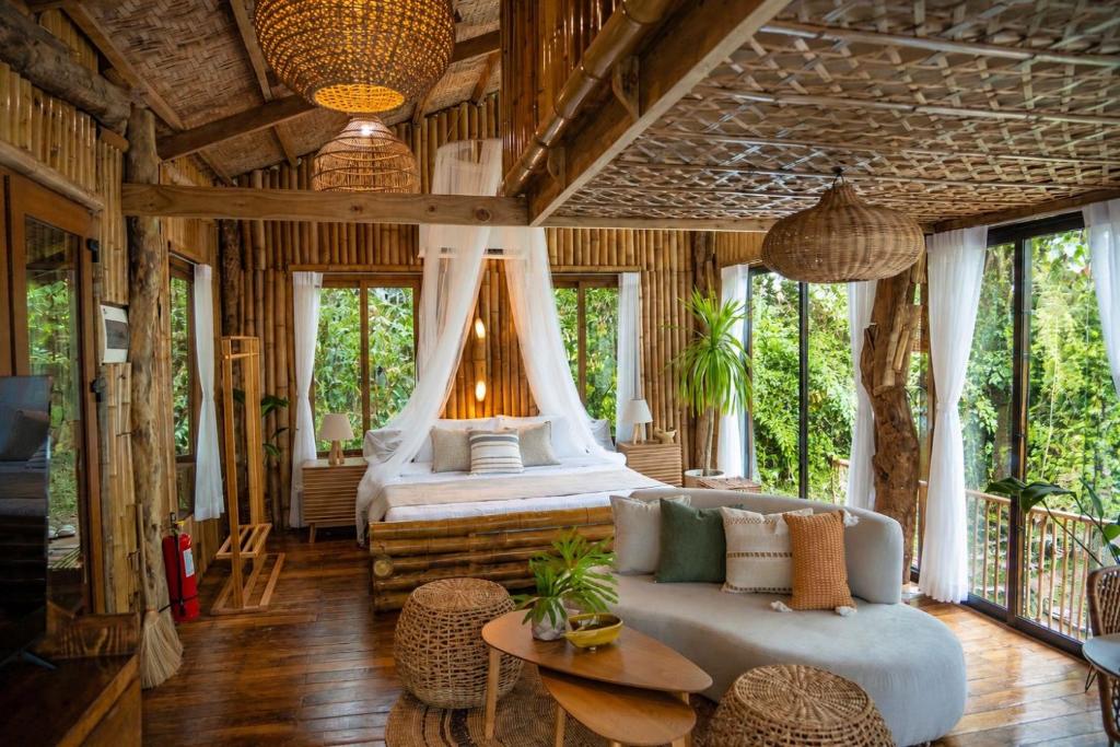 a bedroom with a bed and a couch and a table at Treehouse de Valentine in Balamban