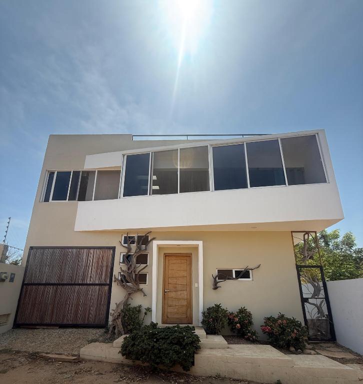 a large white house with a brown door at Pool, Space, Style, Modern House for 8 in Brisas de Zicatela