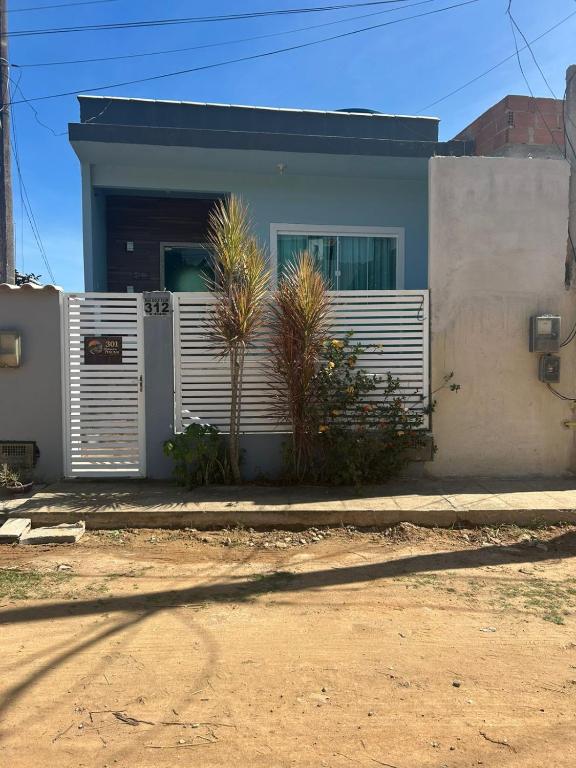 a white fence in front of a house at Refúgios de Itaúna in Saquarema