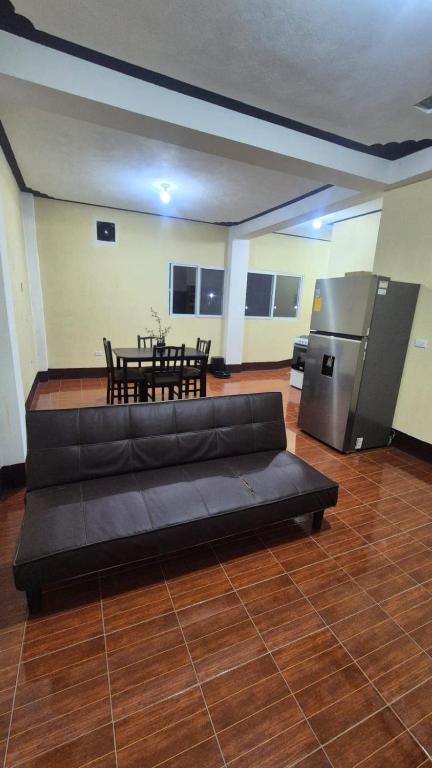 a living room with a black couch and a table at Estadía Climatizada en Escuintla in Escuintla