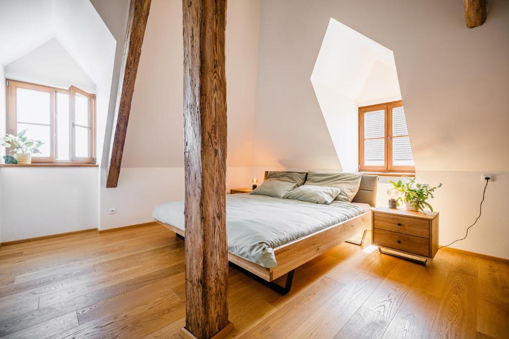 a bedroom with a bed and two windows at Turistka Loft in Kutná Hora