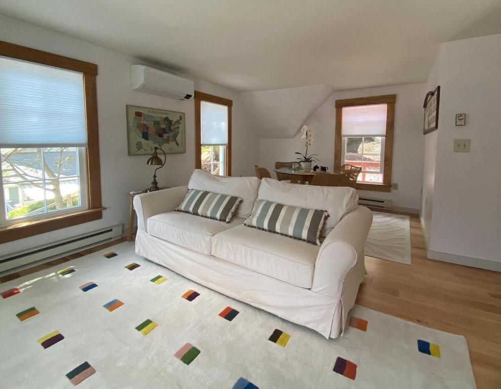 a living room with a white couch and a rug at Sleeping Sailor in Camden