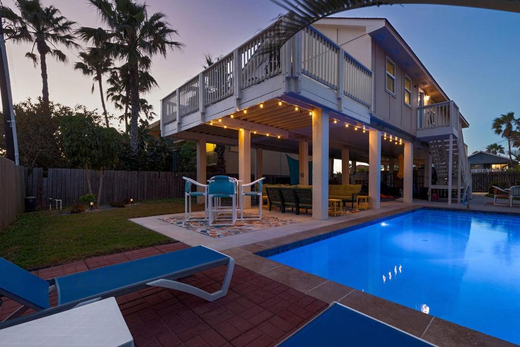 a house with a swimming pool in front of a house at House of Neptune Steps from the sea and private pool in South Padre Island
