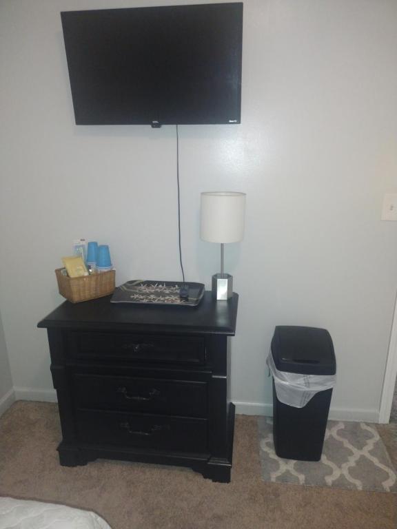 a bedroom with a black dresser with a television on a wall at Lil ranch in White Pine