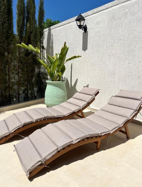 a group of benches sitting on a patio at Villa with large terrace garden & great view, Agadir Anza Blue in Agadir