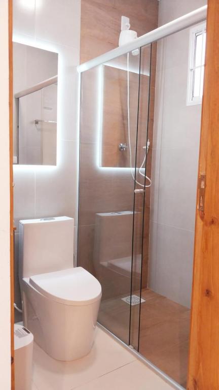 a bathroom with a toilet and a glass shower at São Gabriel Centro Studios & Suítes in São Gabriel