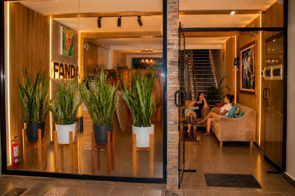 two people sitting in a room with potted plants at Fanda in Sauce