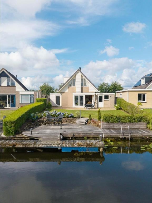 a house with a dock next to a body of water at Villa Water en Meer in Terherne