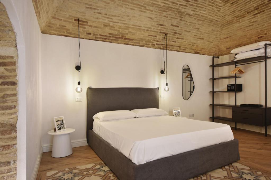 a bedroom with a large bed and a brick wall at B&B Ago e Luce - YourPlace Abruzzo in Vasto