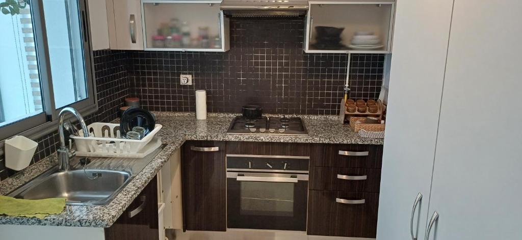 a kitchen with a sink and a stove top oven at Ville n4 in Sidi Daoud