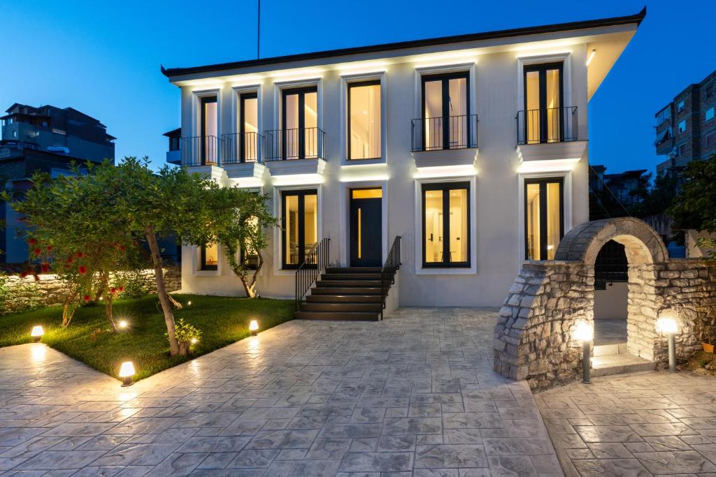 a white house with lights in front of it at Le Mom Apart Hotel in Berat
