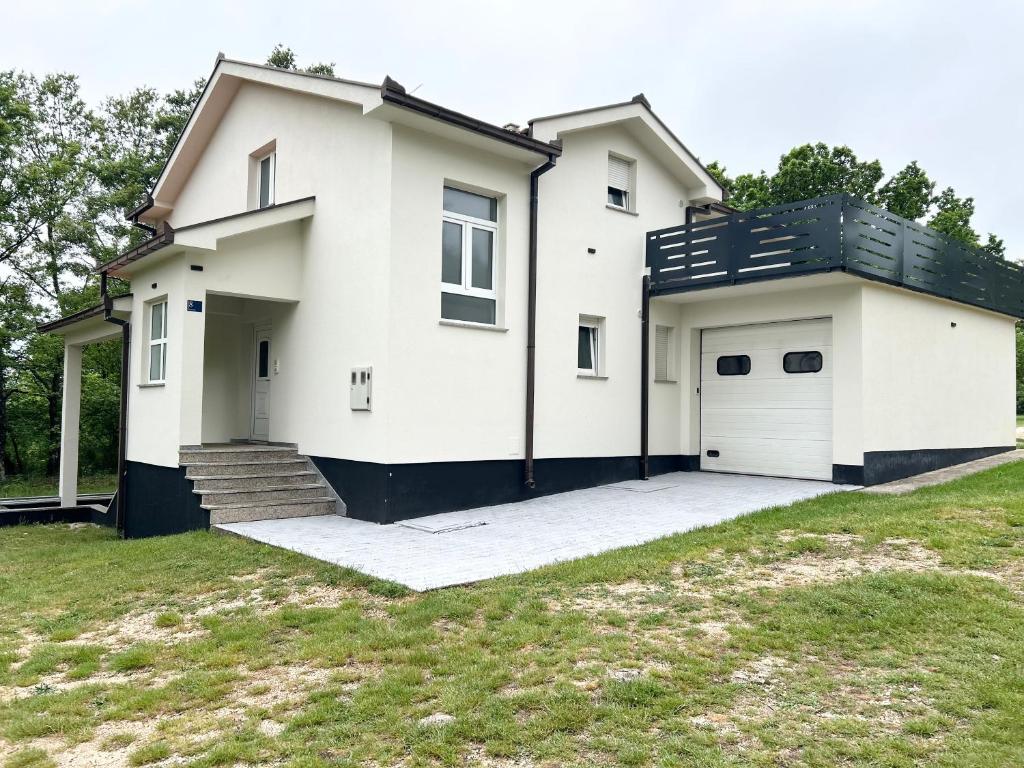 a large white house with a garage at Kovač Home in Posušje