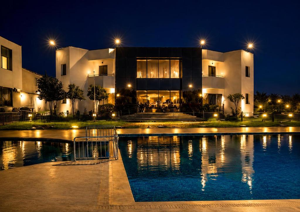a large building with a swimming pool at night at Atlas Safari in Meknès