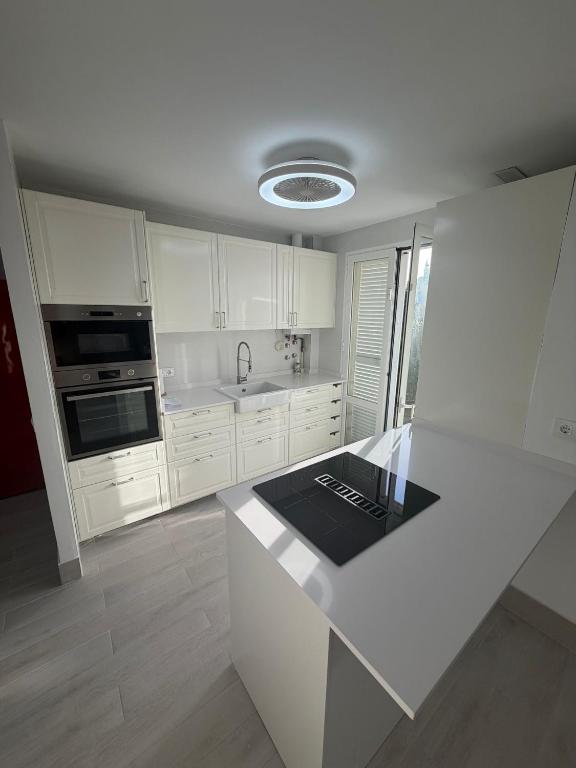a kitchen with white cabinets and a white counter top at Galia costa ballena 2 in Cádiz