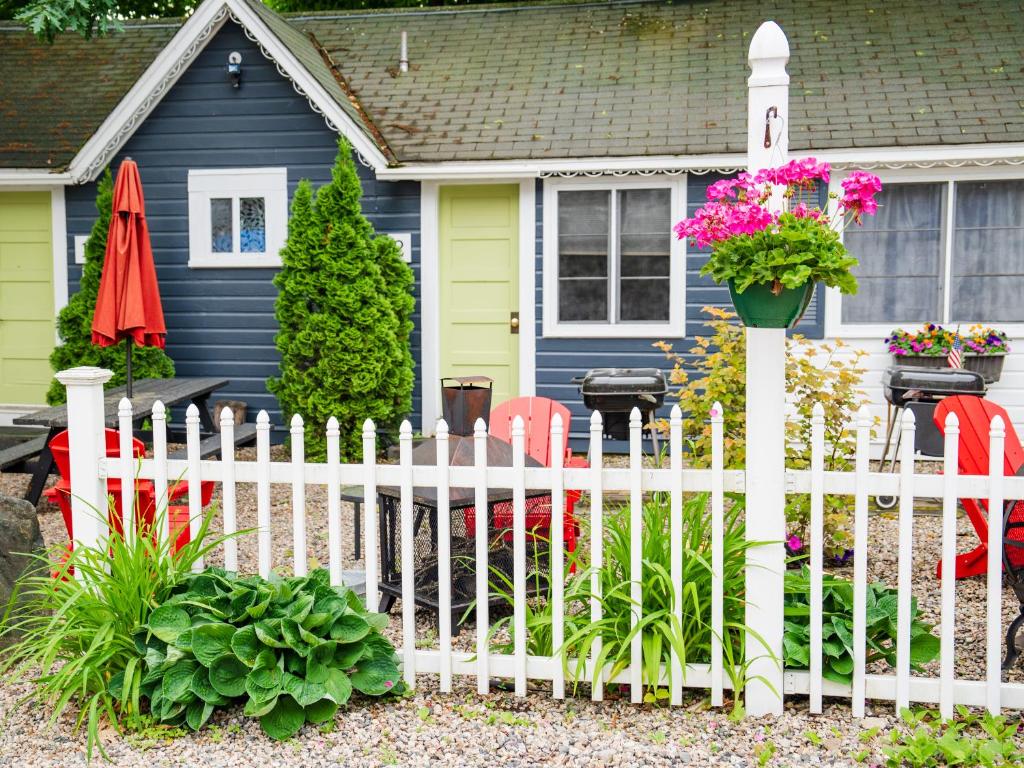 a white picket fence in front of a house at Cottage 1-2 -2 Bedroom 1 Bath End Unit with Kitchenette Private Courtyard Pet Friendly fee applies in Wolfeboro