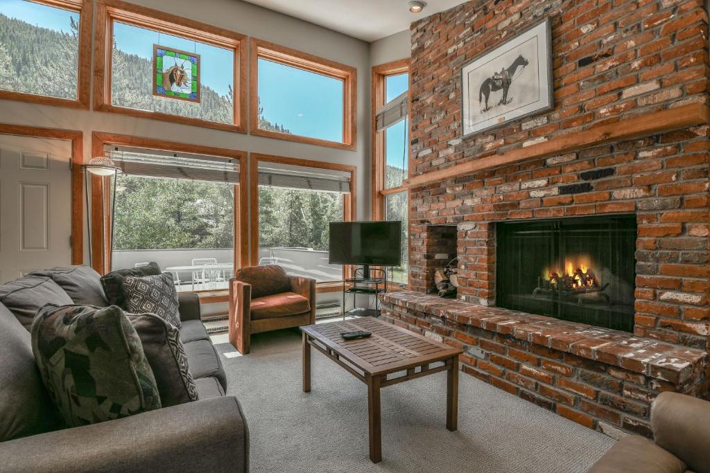 a living room with a brick fireplace at Keystone Bristlecone Home 31 by SummitCove Lodging in Colorado in Keystone