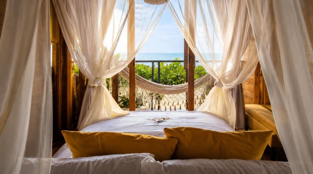 a bedroom with a hammock with a view of the ocean at Luma by Zakua in Guachaca