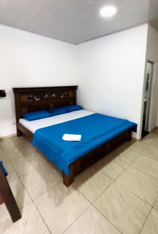 a bedroom with a bed with a blue comforter at Hotel villa dulce campestre in Melgar